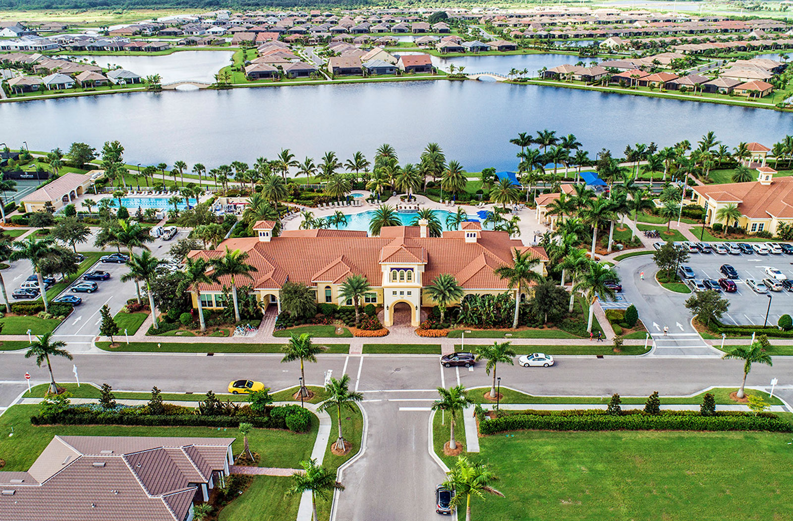 Aerial view of the luxury lakefront community featuring a large clubhouse, and pools