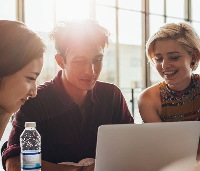 Three college students working together while looking at one computer at the State College of Florida