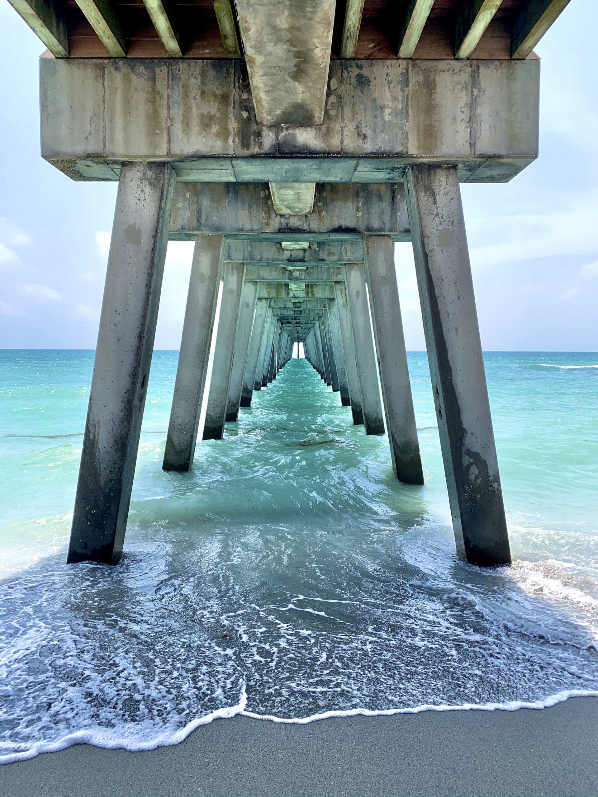 An image taken symetrically underneath the pier showing its tunnel into the water