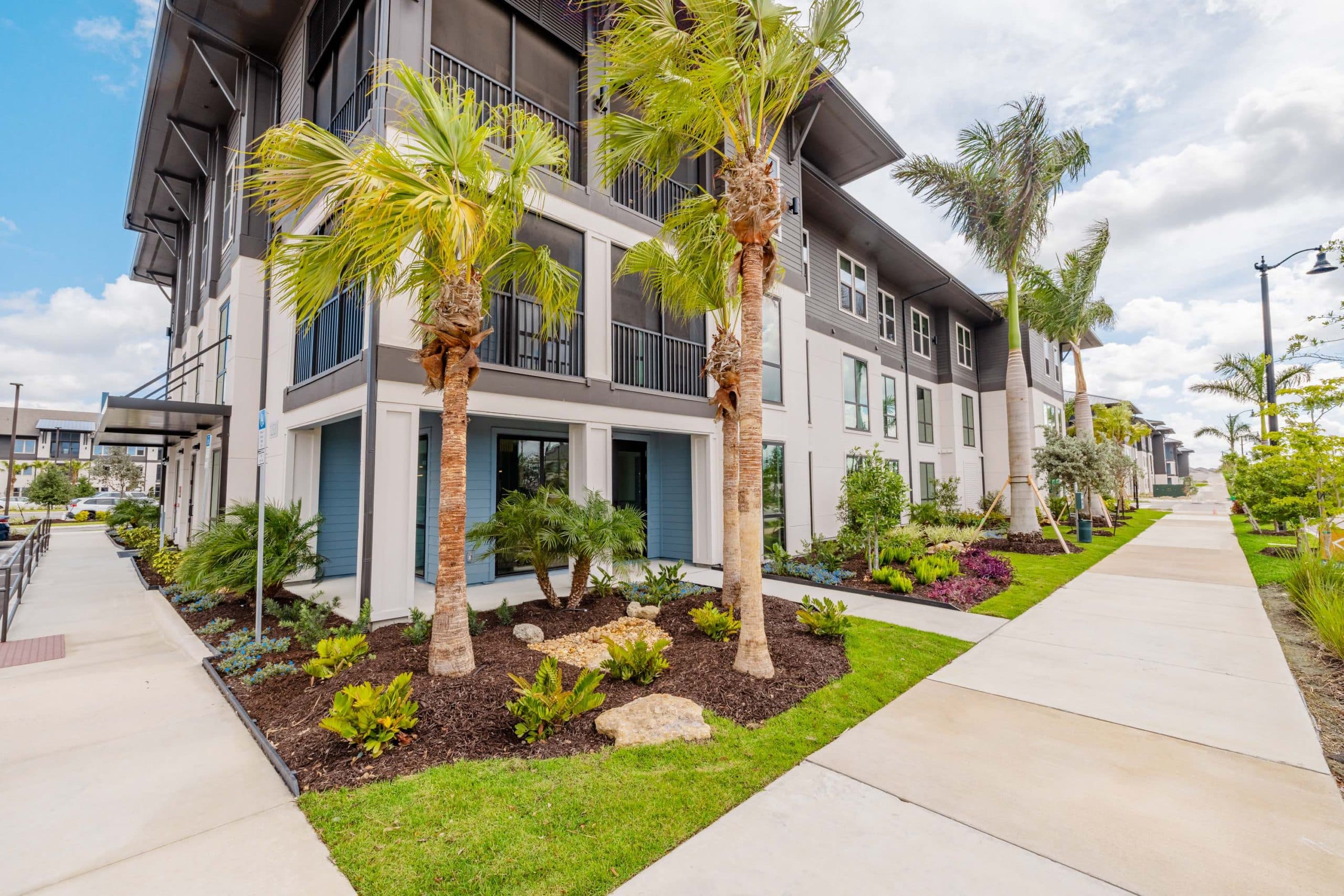 The corner of Tropia at Wellen buildings with decorative palm trees