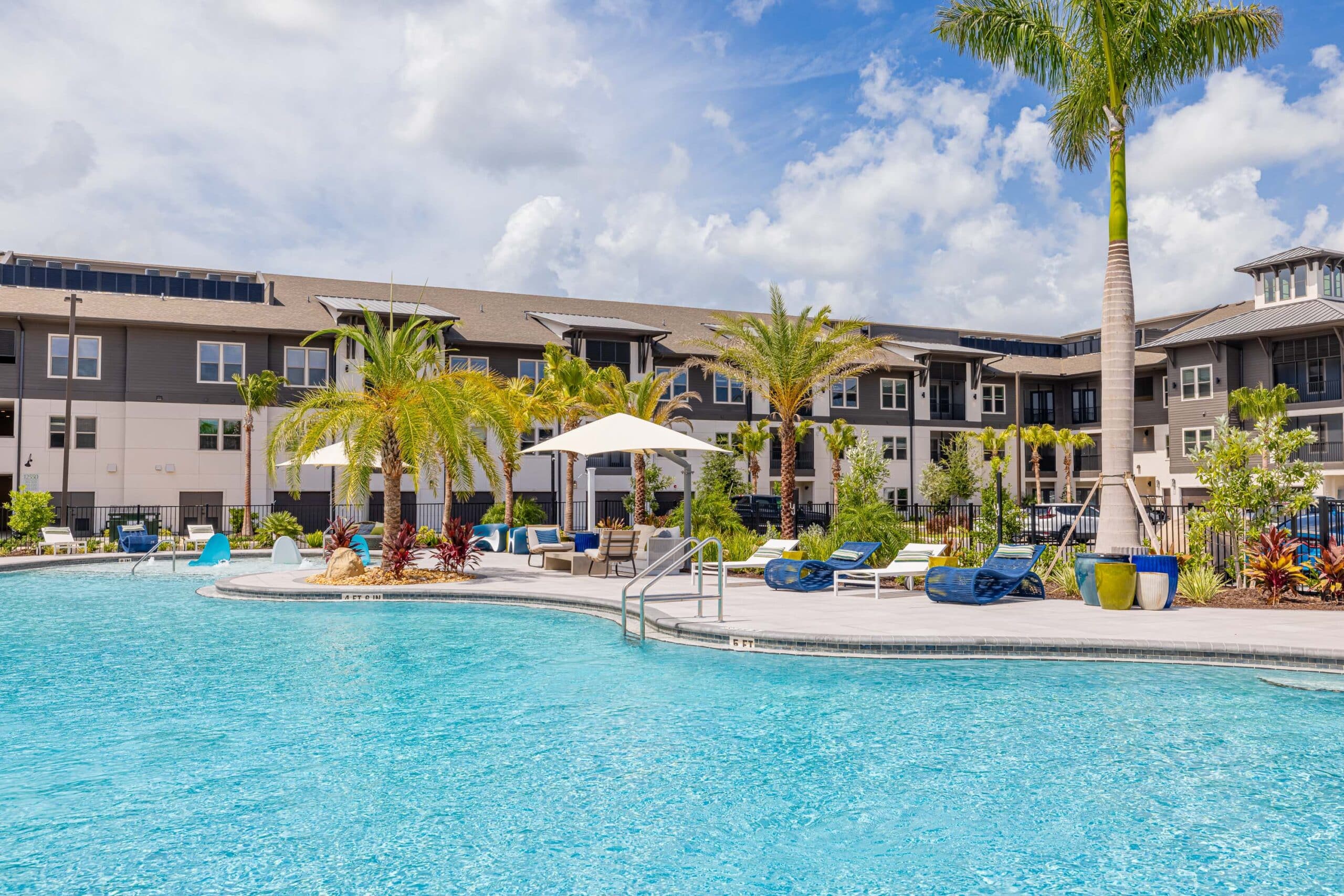 A pool with pool chairs and umbrellas