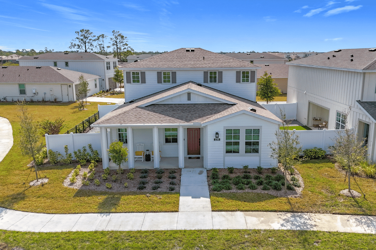 A single family home with two floors and a lawn outside in the daytime